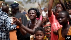 FILE - Women and children refugees cheers the motorcade carrying Central African Republic's interim President Catherine Samba-Panza during her visit to refugee camps in Bangui, Central African Republic, Feb. 1, 2014. 