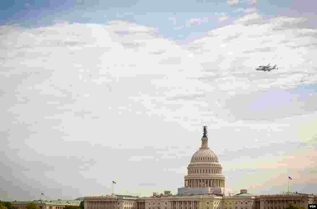 Pesawat ulang-alik antariksa Discovery melakukan penerbangan 'victory lap' di Washington, DC. Dalam foto ini terlihat terbang melintasi Gedung Capitol (foto: VOA/Alison Klein).