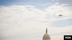 Pesawat ulang-alik antariksa Discovery melakukan penerbangan 'victory lap' di Washington, DC. Dalam foto ini terlihat terbang melintasi Gedung Capitol (foto: VOA/Alison Klein).