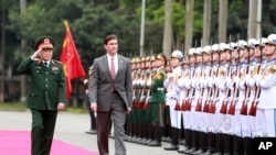 U.S. Defense Secretary Mark Esper, center, and Vietnamese Defense Minister Ngo Xuan Lich review an honor guard in Hanoi, Vietnam, Nov. 20, 2019.