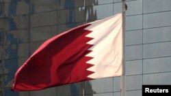 FILE - Bendera Qatar berkibar di depan kantor pusat bank Qatar di Doha, 30 November 2009.