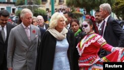 Britain's Prince Charles, front left, and his wife, Camilla, Duchess of Cornwall, are welcomed during the Day of the Dead celebrations in Pachuca, in the Mexican state of Hidalgo, Nov. 2, 2014. 