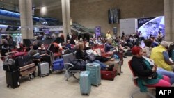 Passengers wait at Ben Gurion Airport near Tel Aviv, Israel, on October 7, 2023, as flights are canceled because of the Hamas surprise attack.