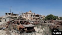 Des voitures incendiées aperçues à côté des bâtiments endommagés lors d'affrontements entre les forces militaires fidèles au gouvernement de l'Est de la Libye et le Conseil Shura des révolutionnaires libyens, une alliance d’anciens rebelles anti-Kadhafi qui ont uni leurs forces avec le groupe islamiste Ansar al-Sharia, à Benghazi, Libye, 24 avril 2016. REUTERS / Esam Omran Al-Fetori - RTX2BF5D