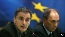 Greece's Finance Minister Euclid Tsakalotos, left, speaks during a news conference as Economy Minister Giorgos Sathakis listens, in Athens, Nov. 17, 2015. 