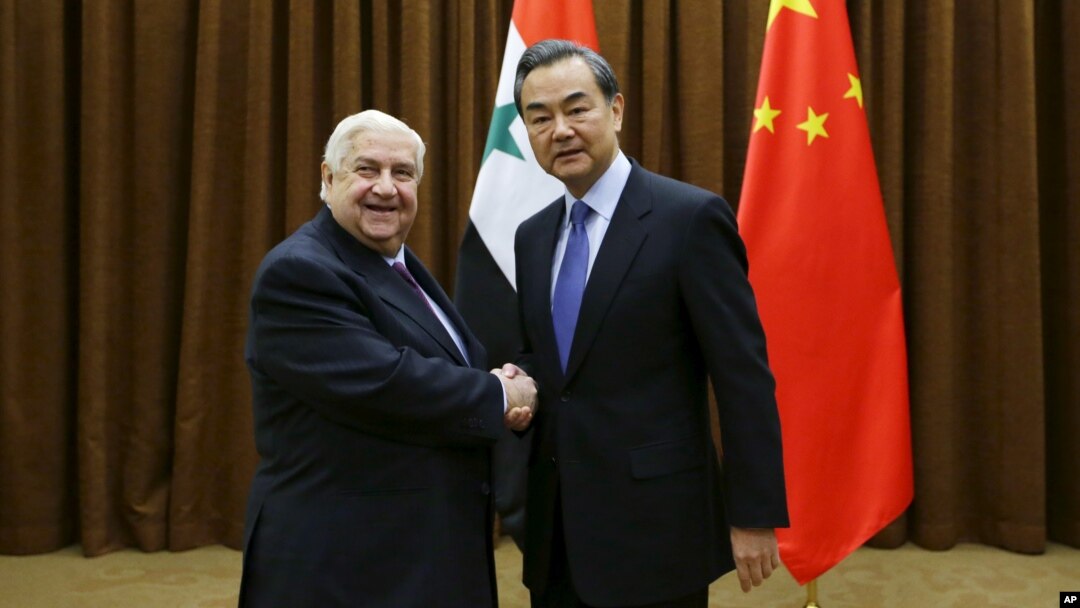 Ngoại trưởng Syria Walid al-Moualem bắt tay Bộ trưởng Ngoại giao Trung Quốc Vương Nghị trước cuộc gặp ở Bắc Kinh hôm 24/12.