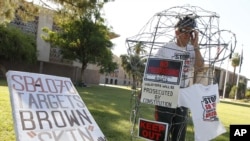 Anh Jorge Mendez đứng trong các dây thép gai tham gia một buổi cầu nguyện phản đối luật di trú nghiêm khắc của tiểu bang Arizona
