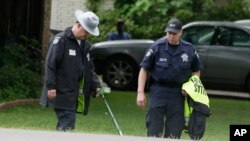 Dallas County Sheriff crime scene investigators use a metal detector at the intersection near where a black teenager was killed by a white police officer, May 3, 2017.