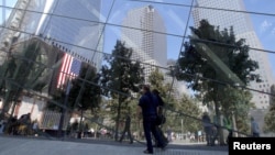 Visitantes son reflejados en las vidrieras del Museo de la Zona Cero del Centro de Comercio Mundial, en Nueva York, cuya construcción está suspendida por disputas financieras.