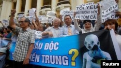 Demonstrators, holding signs to protest against Taiwanese enterprise Formosa Plastic and environmental-friendly messages, say they are demanding cleaner waters in the central regions after mass fish deaths in recent weeks, in Hanoi, Vietnam, May 1, 2016.