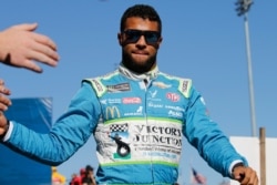 FILE - Bubba Wallace greets fans during a NASCAR Cup Series race at Martinsville Speedway in Martinsville, Va., Oct. 27, 2019.