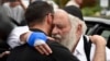 Rabbi Yisroel Goldstein, right, is hugged as he leaves a news conference at the Chabad of Poway synagogue, Sunday, April 28, 2019, in Poway, Calif. 