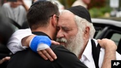 Rabbi Yisroel Goldstein, right, is hugged as he leaves a news conference at the Chabad of Poway synagogue, Sunday, April 28, 2019, in Poway, Calif. 