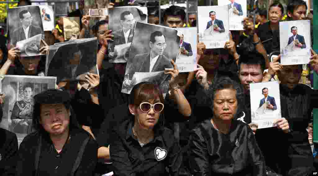 태국 방콕에서 열린 푸미폰 전 국왕의 장례식에서 검은 상복을 입은 참석자들이 국왕의 초상화를 들고 있다.