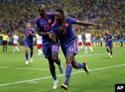 El goleador de Colombia Yerry Mina (derecha), celebra con su compañero de equipo Davinson Sanchez después de anotar el gol de apertura durante el partido del grupo H entre Polonia y Colombia en la Copa Mundial de fútbol 2018 en el Kazan Arena en Kazan, Rusia, el domingo 24 de junio de 2018.