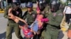 在中國駐金邊大使館外柬埔寨警察抬走一名抗議中國在柬埔寨設立軍事基地計劃的婦女。 （2020年10月23日）