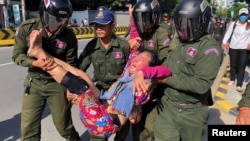 在中国驻金边大使馆外柬埔寨警察抬走一名抗议中国在柬埔寨设立军事基地计划的妇女。（2020年10月23日）