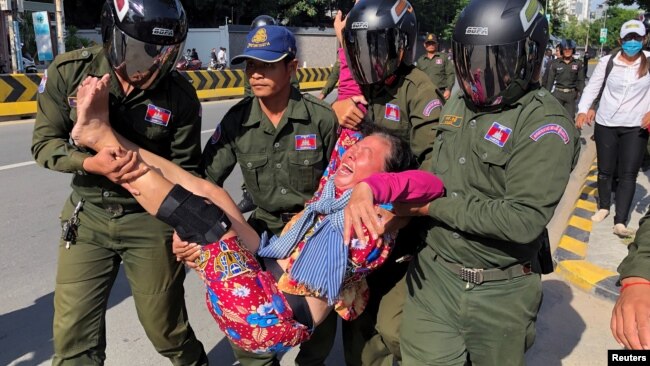 在中国驻金边大使馆外柬埔寨警察抬走一名抗议中国在柬埔寨设立军事基地计划的妇女。（2020年10月23日）