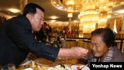 지난 2015년 10월 금강산호텔에서 열린 남북 이산가족 상봉행사에서 남측 박문수(71) 할아버지가 북측에서 온 누나 박문경(83) 할머니에게 음식을 먹여주고 있다. (자료사진)