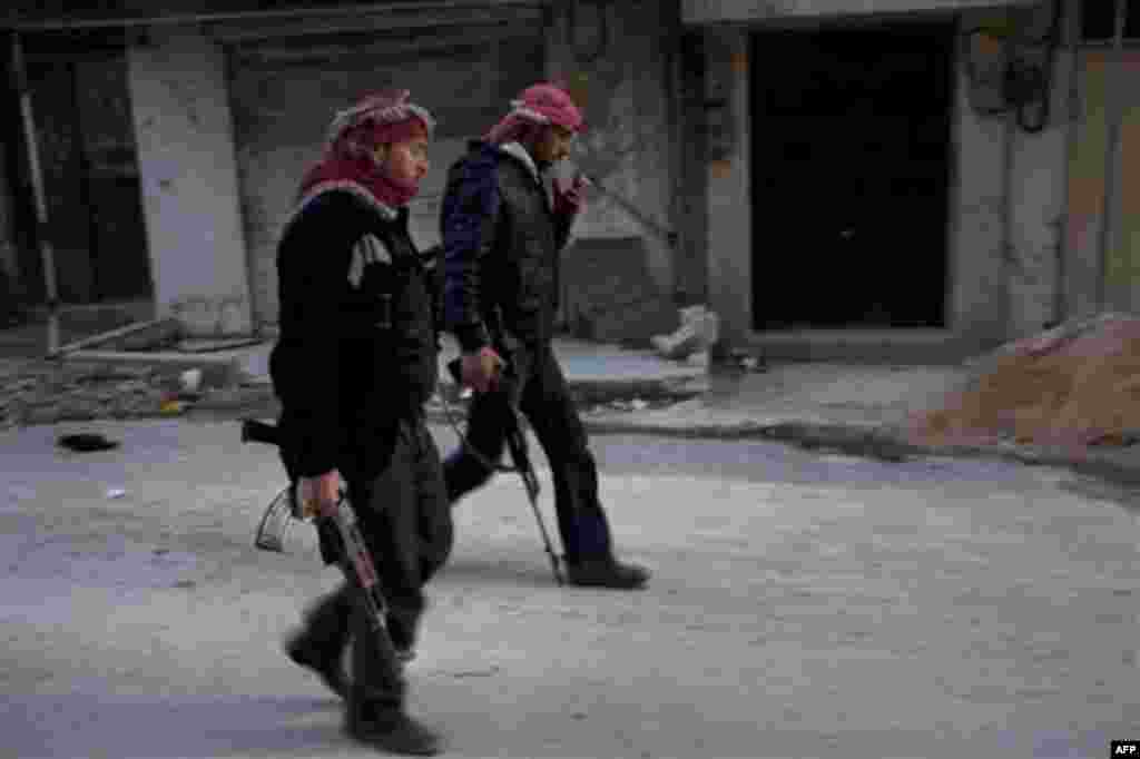 Free Syrian Army fighters walk towards a check point near their headquarters in Kafar Taharim, north Syria, Friday, Feb. 24, 2012. (AP Photo/Rodrigo Abd)