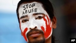 An Indian protester with a slogan painted on his face participates in a demonstration to protest against police inaction after a 6-year-old was allegedly raped in a school in Bangalore, India, July 20, 2014. 