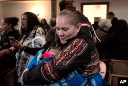 Jessie "Little Doe" Baird (R) hugs a member of the audience following celebration at the Old Indian Meeting House, in Mashpee, Mass., Nov. 18, 2017. Baird and other linguists are working reclaim the language of the Wampanoags, the tribe that helped the P