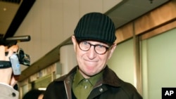 Australian missionary John Short walks out from the airport terminal as he arrives at Beijing International Airport in Beijing, China, Monday, March 3, 2014