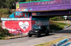 A vehicle drives by a tribute to the victims of the Naval Air Station Pensacola shooting, on what’s known as Graffiti Bridge in downtown Pensacola, Florida, Dec. 7, 2019.