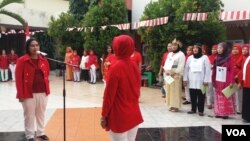 Anggota DPR Irma Chaniago bersama sekitar seratur kaum ibu anggota tiga sekolah perempuan di Bantaran Kali Ciliwung, Jakarta mengikuti upacara bendera, Kamis (17/8) di Gelanggang Remaja. (VOA/Fathiyah)