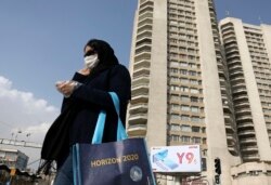 Seorang pejalan kaki mengenakan masker melintasi jalan di Teheran utara, Iran, Minggu, 1 Maret 2020. (Foto: dok).