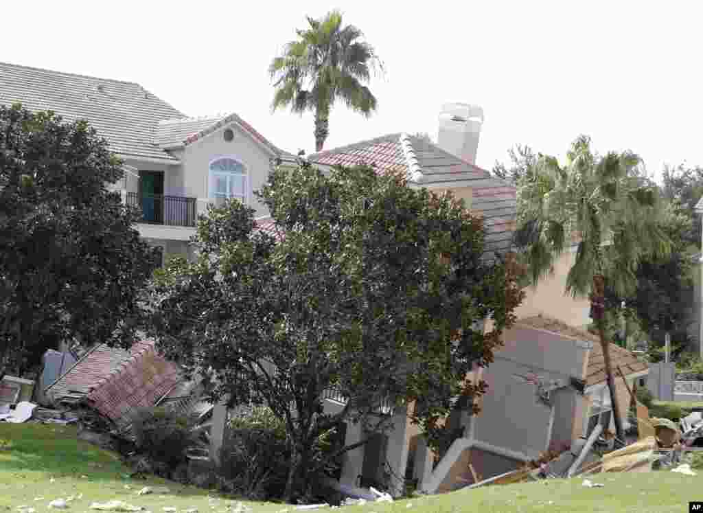 A portion of a building is in a sinkhole in Clermont, Florida, USa, Aug. 12, 2013. The sinkhole, 40 to 50 feet in diameter, opened up overnight and damaged three buildings at the Summer Bay Resort. 