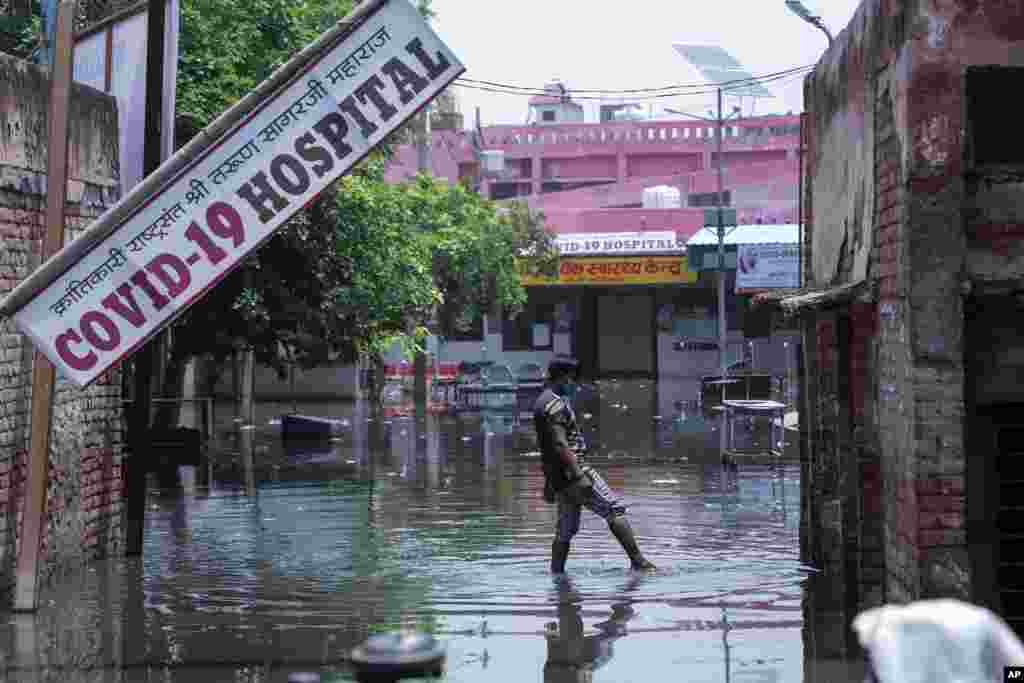 A worker tries to clear water after heavy rains flooded the premises of a COVID-19 hospital at Ghaziabad, outskirts of New Delhi, India, May 23, 2021.