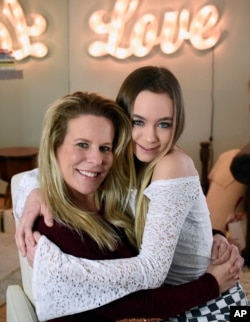 In this Feb. 28, 2018 photo, Matty Nev Luby, right, and her mother Kerrylynn Mahoney pose together for a photograph in Wethersfield, Conn. The high school gymnast’s popularity on the lip-syncing app Musical.ly, which merged this summer into the Chinese vi