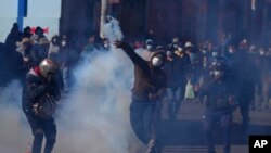Un cultivador de coca arroja una lata de gas lacrimógeno disparada por la policía antidisturbios, durante enfrentamientos cerca del mercado de coca en La Paz, Bolivia, el 29 de septiembre de 2021. 