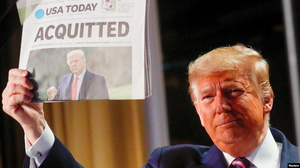Eski Başkan Trump, geçen yıl ilk azil davasında beraat etmesinin ardından 6 Şubat 2020'de Washington'da katıldığı Ulusal Dua Kahvaltısı'nda USA Today gazetesinin baş sayfasında yer alan haberi gösteriyor. 