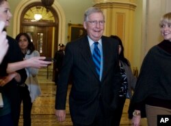 FILE - Senate Majority Leader Mitch McConnell, R-Ky., listens to questions from reporters as he walks to his office after speaking on the Senate floor at the Capitol, Jan. 21, 2018, in Washington.