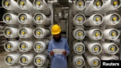 FILE - A worker stands at a desalination plant, 35 km south of Riyadh, May 4, 2011.