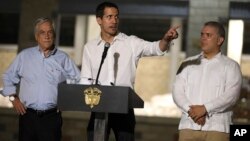 Venezuela's opposition leader Juan Guaido speaks flanked by Chile's President Sebastian Pinera, left, and Colombia's President Ivan Duque in front of a warehouse housing U.S. humanitarian aid destined for Venezuela, in Cucuta, Colombia, Feb. 22, 2019.