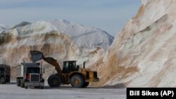 Road salt is loaded into trucks at Eastern Minerals Inc., Wednesday, Jan. 3, 2018, in the Boston suburb of Chelsea in Massachusetts. (AP Photo/Bill Sikes)