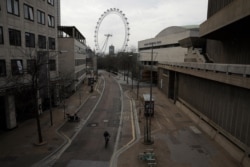 Big Ben's clock tower and the London Eye ferris wheel stand in the distance as the area around Royal Festival Hall is very quiet in London, April 8, 2020.