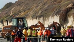 Emergency responders attend to a cliff collapse at a beach in Encinitas, Calif., Aug. 2, 2019. Three women were killed in the collapse.