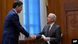Attorney General Jeff Sessions shakes hands with FBI Director James Comey, left, at the start of a meeting with the heads of federal law enforcement components at the Department of Justice in Washington, Feb. 9, 2017.
