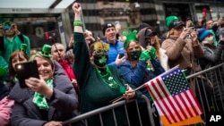 ARCHIVO - Personas observan el desfile del Día de San Patricio en la Quinta Avenida, el 17 de marzo de 2022, en Nueva York, en la primera celebración masiva de la festividad tras una pausa de dos años por la pandemia de COVID-19.