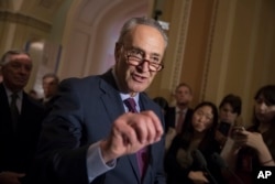 FILE - Senate Minority Leader Charles Schumer, D-N.Y., reacts to questions from reporters on Capitol Hill in Washington.