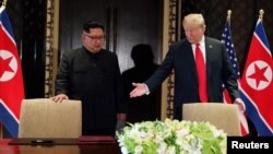 지난 6월 12일 싱가포르 카펠라 호텔에서 도널드 트럼프 미국 대통령(오른쪽)과 김정은 북한 국무위원장이 정상회담 공동성명에 서명하기 위해 들어서고 있다.