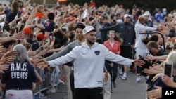 Ty Jerome and other members of the Virginia basketball team are welcomed by fans as they return home after their win of the championship in the Final Four NCAA college basketball tournament against Texas Tech, in Charlottesville, Va., Tuesday, April 9, 2019. 