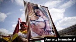 Seorang peziarah dari Meksiko membawa lukisan Paus Yohanes Paulus II saat berada di Alun-Alun Santo Petrus di Vatikan (26/4). (AP/Andrew Medichini)