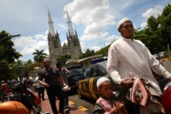 Umat Muslim Indonesia tiba di masjid Istiqlal yang terletak di seberang Katedral Jakarta pada 29 Maret 2013. (Foto: AFP)