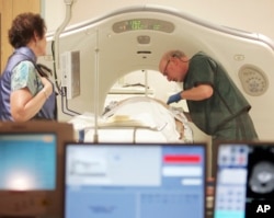 FILE - A physician uses a CT scanner to screen a patient for lung cancer at Southern New Hampshire Medical Center in Nashua, N.H.