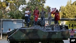 在安卡拉的军部附近，土耳其人站在被示威者破坏的装甲运兵车上（2016年7月16日）